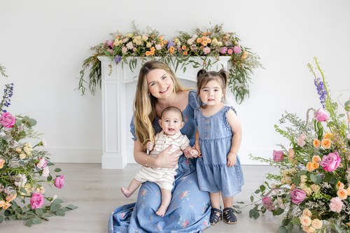 Mother cuddling her daughter in a floral studio setting