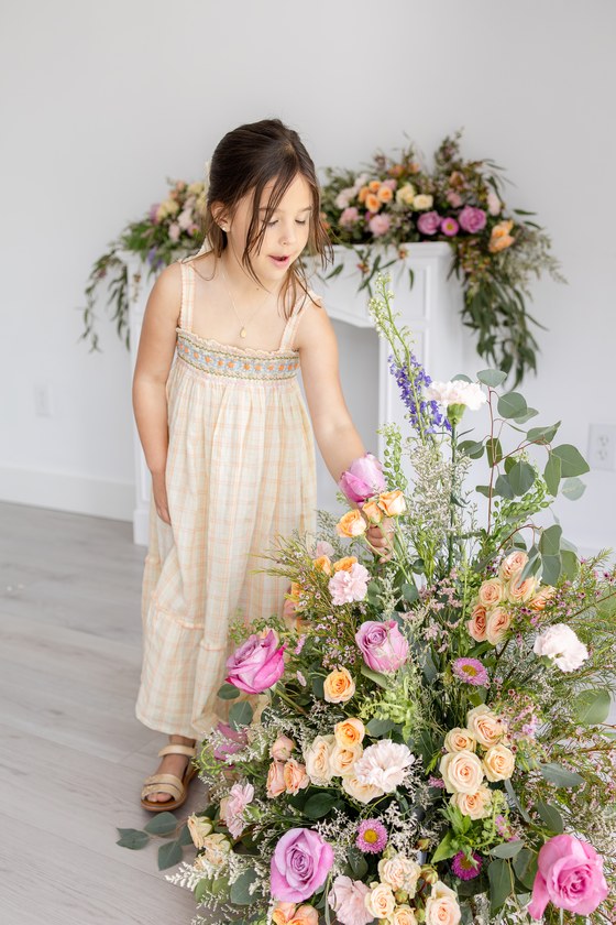 Mother and daughter posing together in a floral studio setting