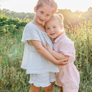 Mother holding her young child in a flower field