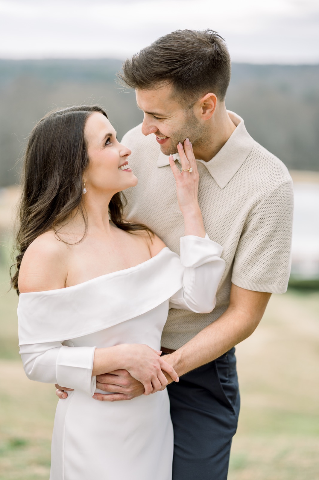 Engaged couple embracing in a soft outdoor portrait