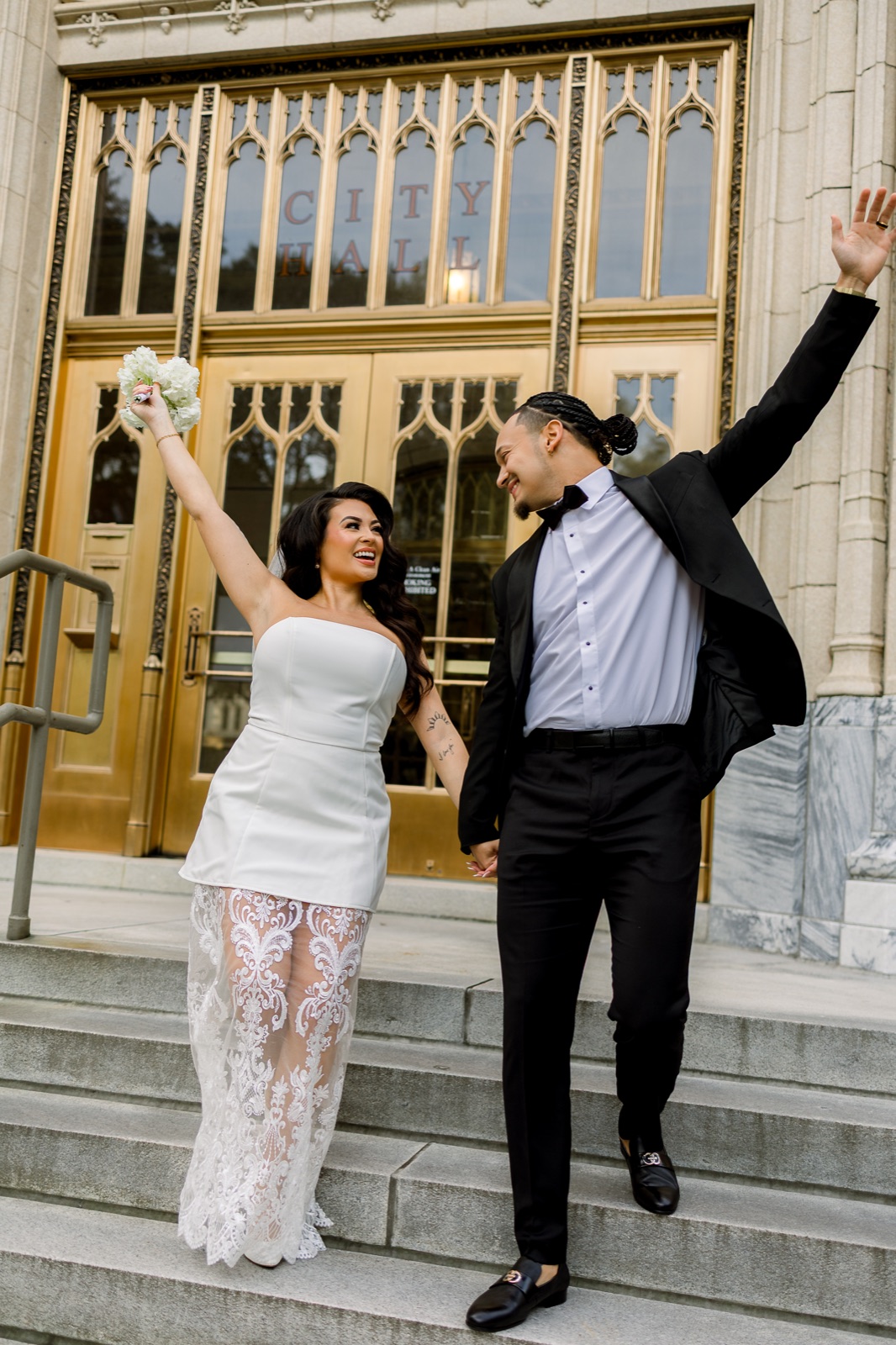 Couple celebrating hand in hand on the city hall steps