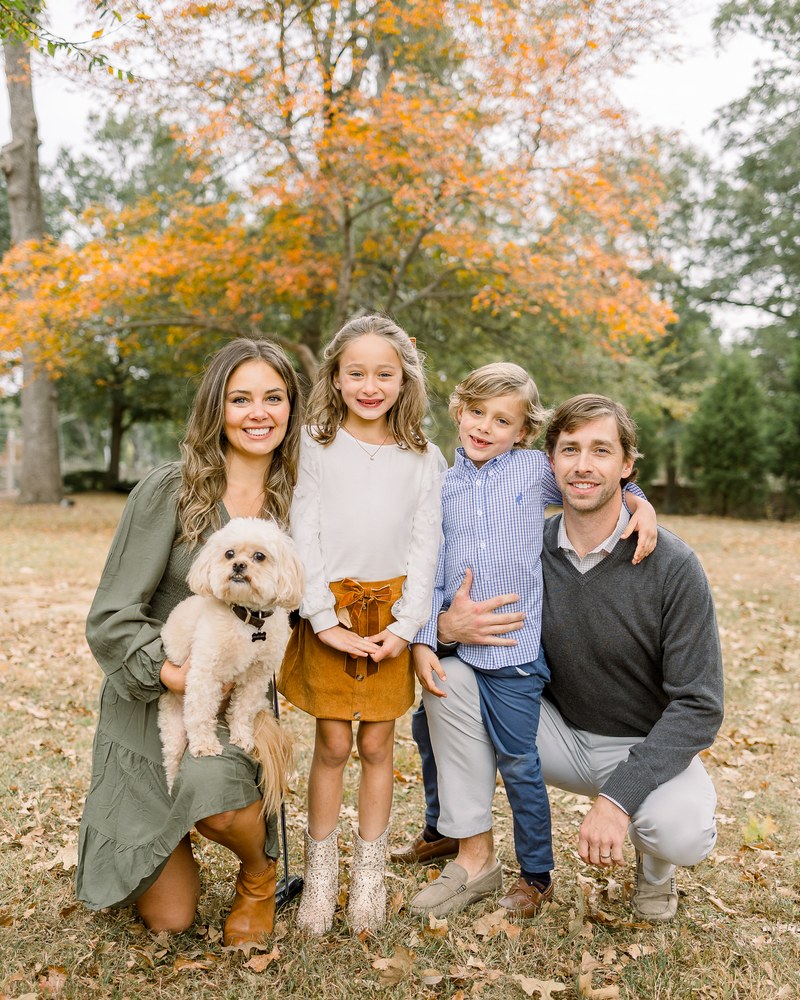 Family of four walking together outdoors in autumn