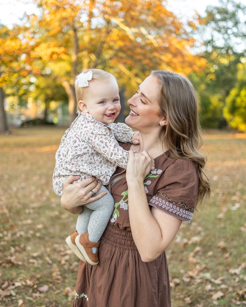 Mother smiling with her baby during an autumn family session
