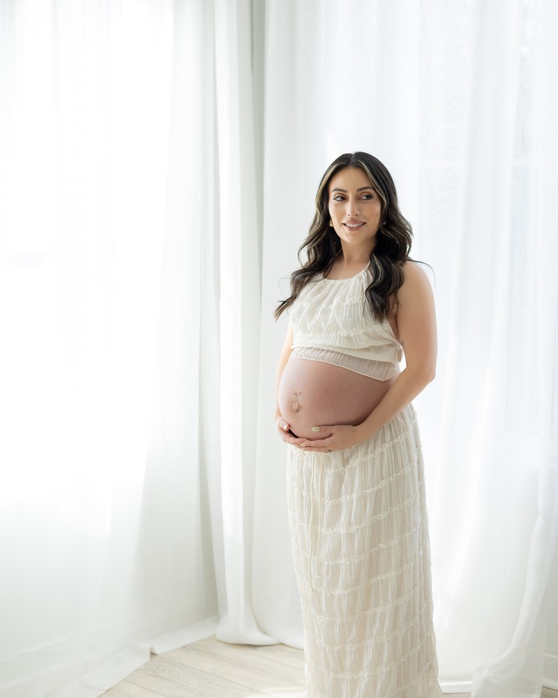 Expectant mother standing in soft window light