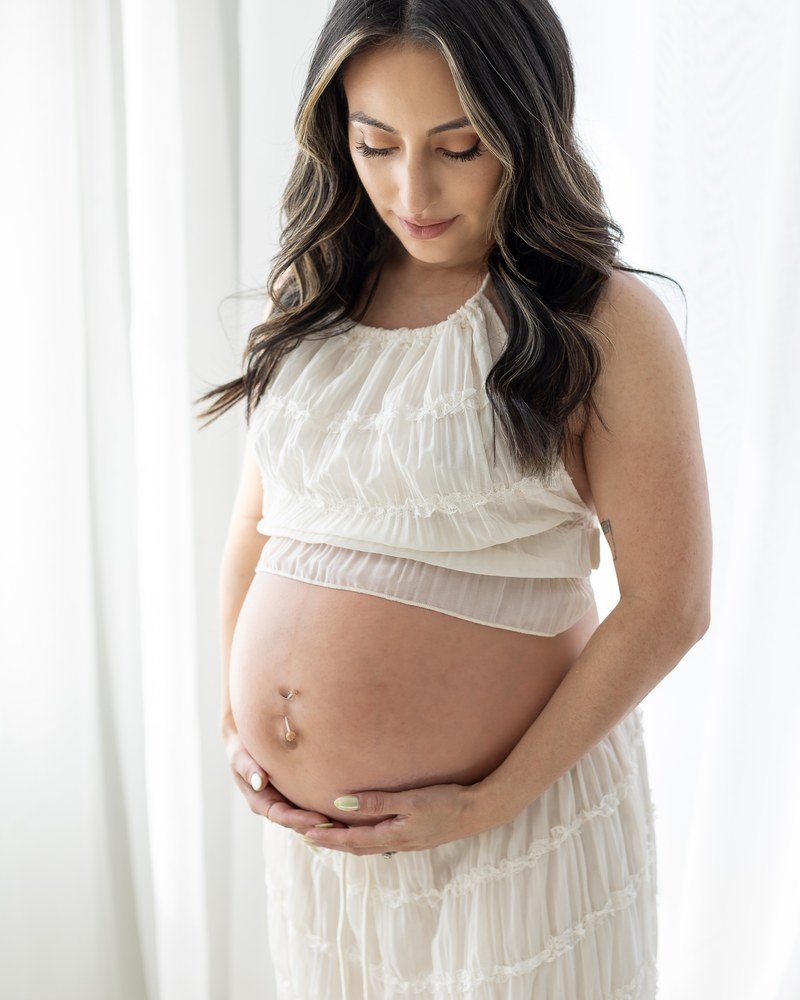 Expectant mother standing in soft window light