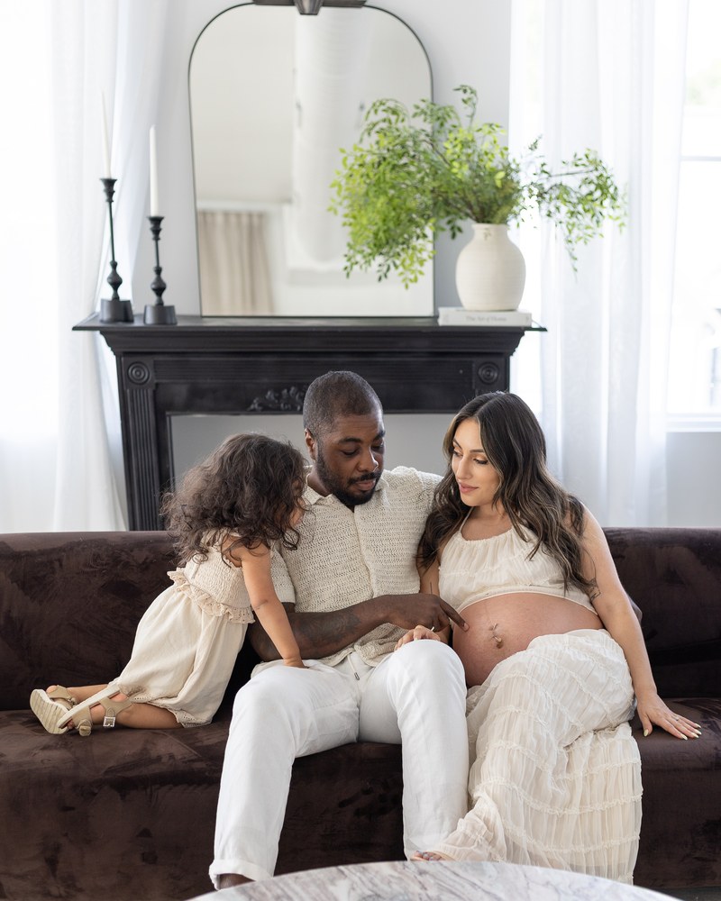 Expectant family gathered in a bright studio
