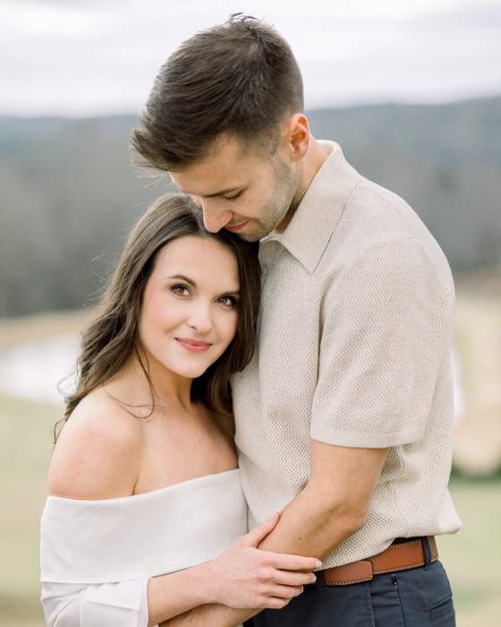 Engaged couple holding one another outdoors